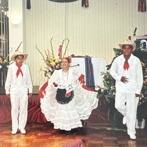 two young men and a young woman in traditional dancing costume