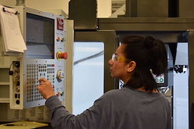 young woman operating precision machining equipment